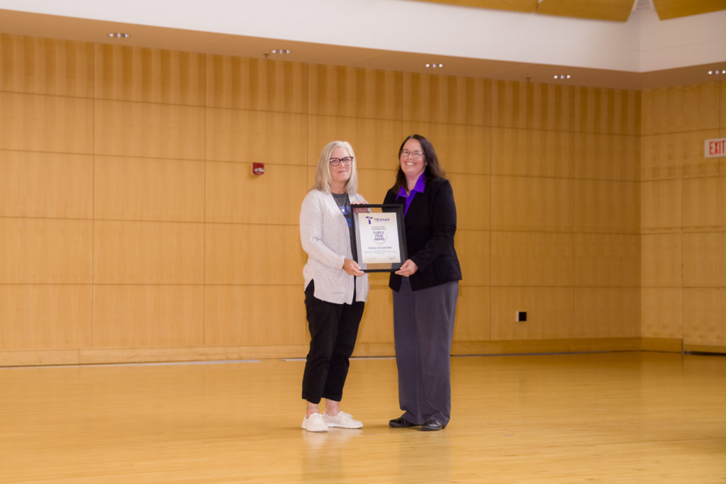 Paula McCartney accepts the Purple Pride Award from Human Resources Director Melissa Garzanelli.